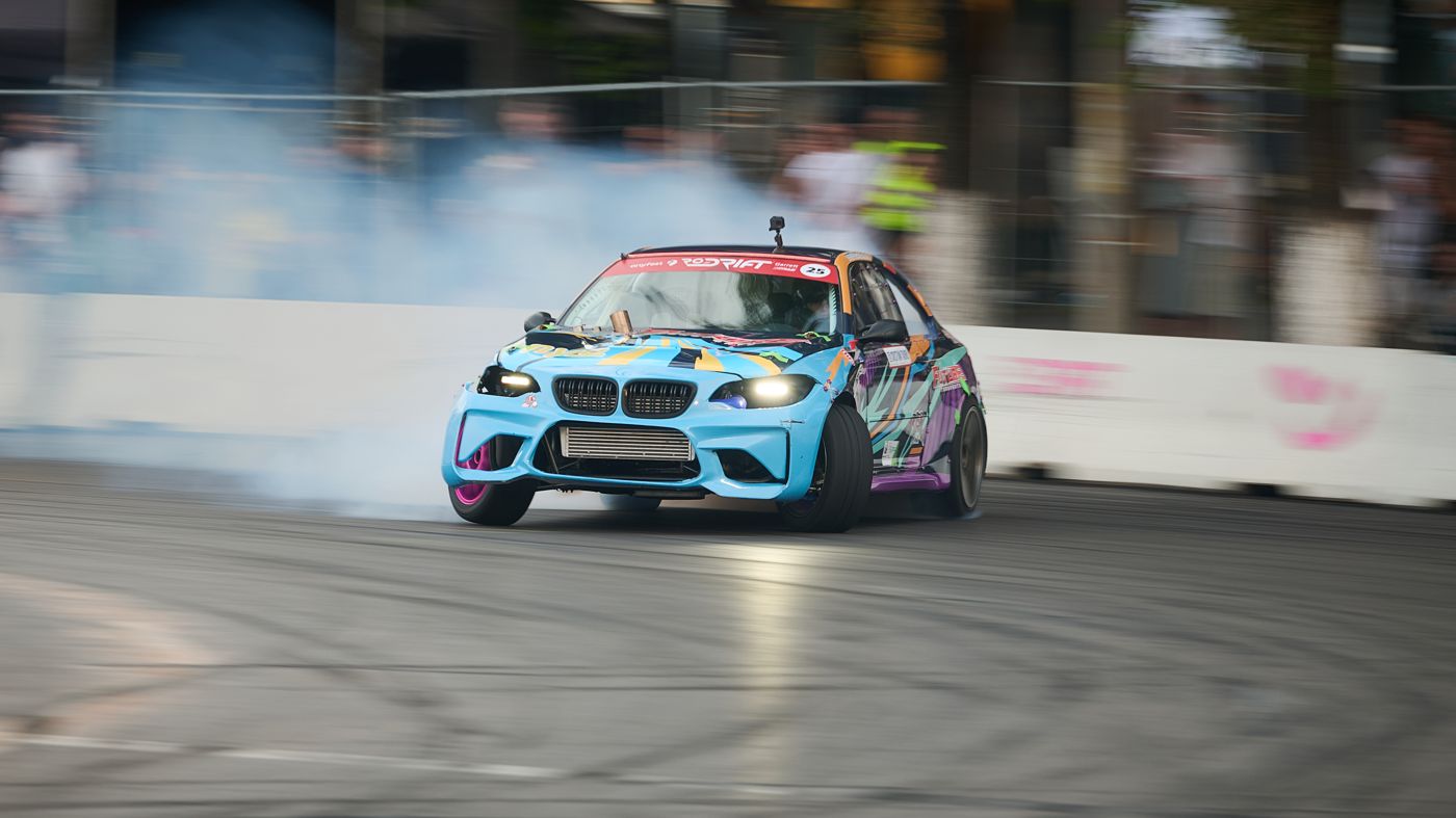 Pilotul Toro Drift cu casca în mână, lângă mașina de competiție